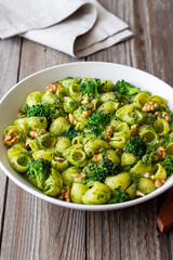 Pasta with broccoli, pesto sauce and nuts. Italian cuisine. Healthy eating.