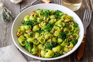 Pasta with broccoli, pesto sauce and nuts. Italian cuisine. Healthy eating.