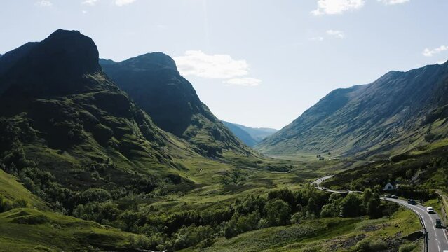 Aerial shot of cars passing through Scotland's famous Glencoe Valley.