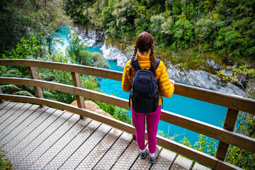 beautiful girl enjoying the view of hokitika gorge from the bridge; unique scenery of new zealand south island