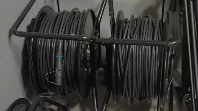 Close up image of audio cables organized on black storage reels in a music studio or production setting