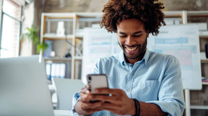 Happy man using a smartphone during his work in the office
