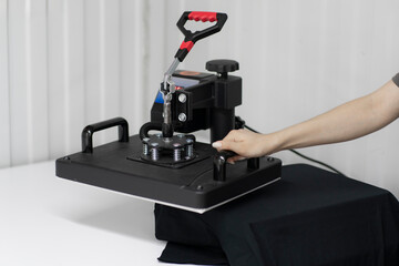 a girl makes new craft t-shirt with textile print using press printer machine