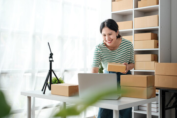 Startup small business entrepreneur or freelance Asian woman using a laptop with box, Young success...