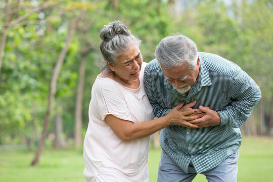 asian senior man suffering and having chest pain from heart attack in the park