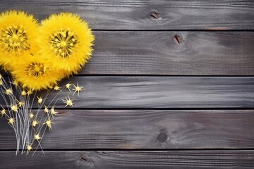 	
Yellow dandelion heart on grey wooden background