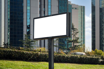 A large information display for outdoor advertising is installed on the street near the road.