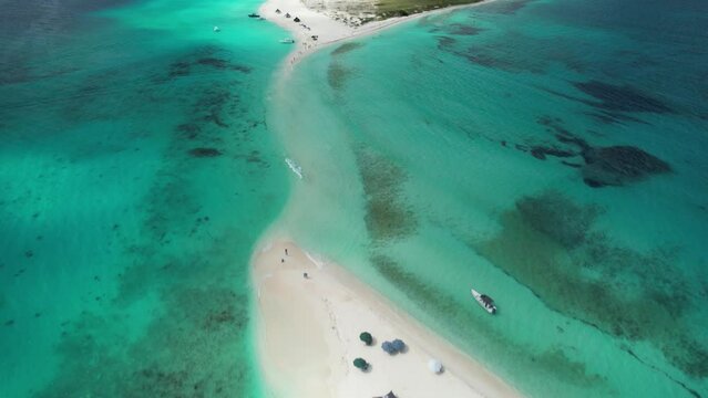 The pristine los roques archipelago with clear turquoise waters, white sandy beach, and anchored boats, aerial view