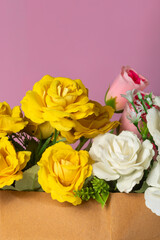 Beautiful bouquet of yellow and white roses on a pink background. close-up