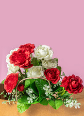 Bouquet of red and white roses on a pink background with copy space for your text.