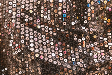 Texture of shining sequins evening dress textile, close-up