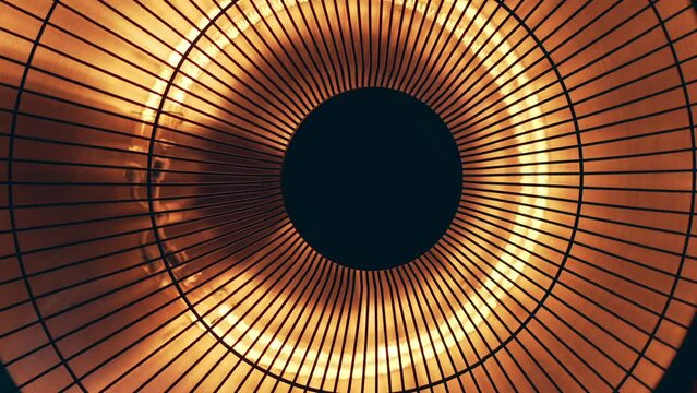 Detailed close up view of round electric heater in orange and yellow color as abstract tech background.
