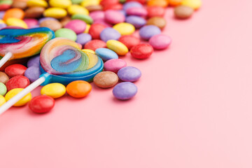 Colorful sweet jelly candies and lollipops. Sweet candies on pink background.