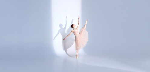 Graceful Ballet Beauty. Athlete showcases ballet prowess in white tutu against white studio...