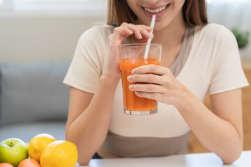 Orange detox juice concept, smile asian young woman hand holding a glass of vegetable juice, carrot...