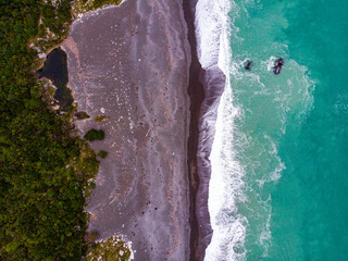 aerial panorama of beautiful nape nape beach in north canterbury, new zealand; black sand beach with turquoise water and large cliffs 