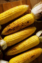 Grilled sweet corn on wooden board.