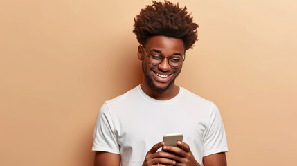 Naklejka premium young man with curly hair wearing glasses and a white T-shirt, smiling while looking at his smartphone