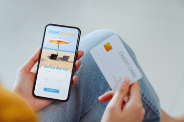 Woman hands using credit card for payment on smartphone with application booking flight travel search ticket holiday and hotel on website.
