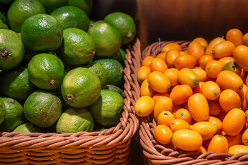 Baskets of limes and kumquats at the market, close-up.