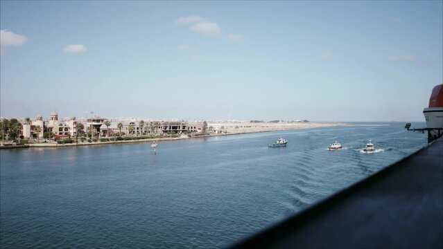 Pilot boats sailing with a cruise ship in the entrance of the Suez Canal in Egypt.