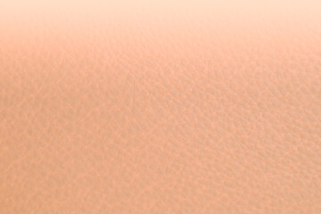 Close up of peach fuzz leather gradient background. Light peach leather texture. Trend color year...