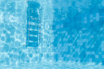 Underwater view of a serene swimming pool corner, with a metal ladder and the water's caustic patterns reflecting on the blue tiled walls and floor. Relaxation and leisure concept. © Antonio Solano