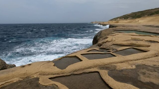Aerial view of Salt Pans cliffs on the northernmost Maltese Archipelago, wavy Mediterranean sea. 