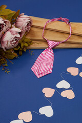 Close-up shot of a short women's tie with print. Pre-tied pink striped tie with an adjustable strap...