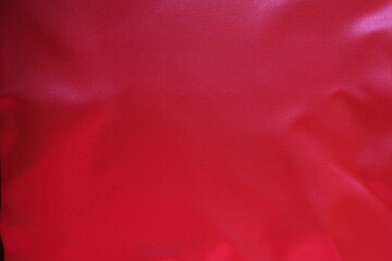 Top view of vibrant reddish pink satin polyester fabric