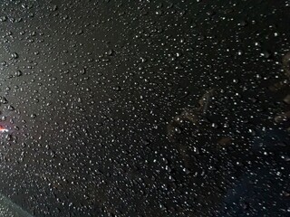 Rain drops on window windshield jaw drop in city at night travel