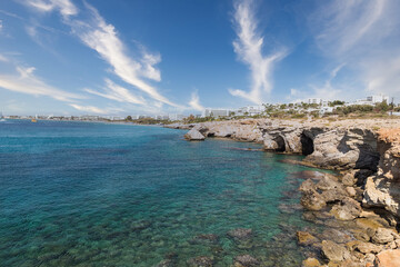 Vacation resort of Ayia Napa. A paradise for vacationers. A sunny day with a blue sky and white clouds. Panoramic view of the hotels, the blue lagoon and the coastline with rocks and caves. Cyprus. 