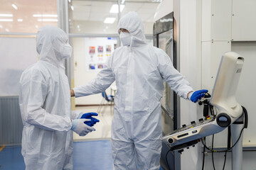 Professional Heavy Industry Robotics Engineer Wearing White Coat Holding Tablet Computer Works in Laboratory. Facility Full of Computers, control robot.