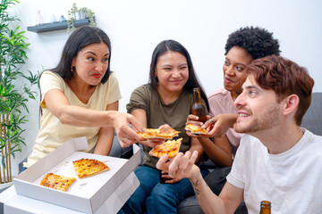 Group of friends sharing laughs and pizza slices in a cozy home environment. 