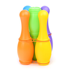 Multi colored bowling pins and a bowling ball isolated on a white background. Children's plastic bowling set, close-up. Active sports games, children's leisure