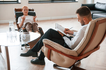 Woman is sitting in chair at an appointment with a psychologist