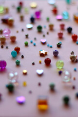 Various colorful beads on bright pink background. Selective focus.