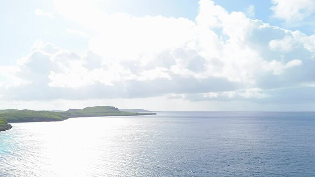 Aerial pan follows frigate birds soaring above tropical coastline oceanic waters