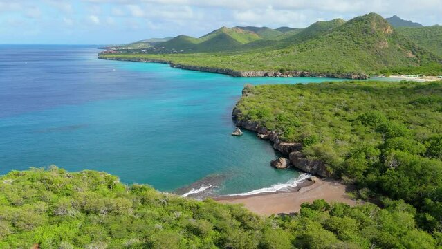 Drone obit around playa Santu Pretu tropical getaway with Christoffelberg and Westpunt in distance
