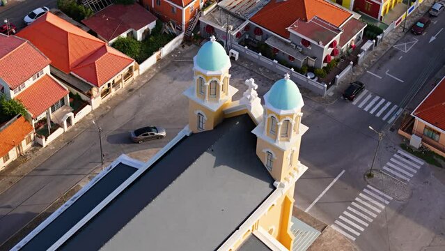 Aerial ascending establishes pastel orange chapel towers of Santa Famia Otrobanda Curacao