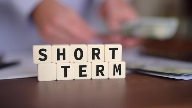 Concept of short term investment. Selective focus and a person counting cash on the background.