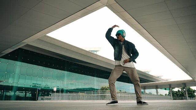 Panorama shot of happy hipster dance together while listen music from headphone at mall. Professional break dancer enjoy perform b boy footstep. Outdoor sport 2024. Modern street dancing. Sprightly.