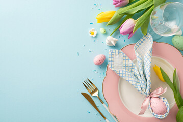 Springtime Elegance: Overhead shot showcasing a delightful table setting with bunny ear napkin, plate, cutlery, wine glass, tulips, sugar sprinkles, eggs. Pastel blue background with space for text