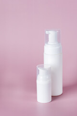 White cosmetic bottle mockup on pink background. Minimalist product still life Beauty blogging Cosmetic background Hygiene, skin and body care. Copy ad space Vertical