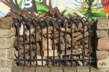 Gartenzaun aus Metall mit aufgestapeltem Brennholz, Deutschland