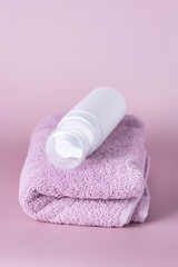White cosmetics container mockup with towels on Pink background Vertical