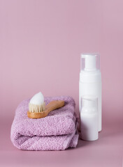 Obraz na płótnie Canvas Blank cosmetic packaging mockup Jar of face foam and towels on Pink Background Vertical