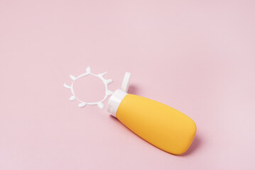Sunscreen Background Cream in the form of sun SPF on pink background Copy Space