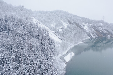 ドローン撮影：真っ白な雪に覆われた川と山