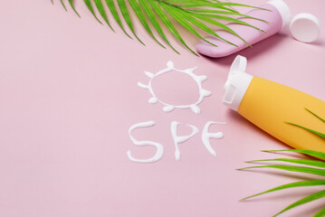 Mockup of Yellow and Pink cosmetic tube with sunscreen Cream in the form of sun SPF on pink background Copy Space Leaf